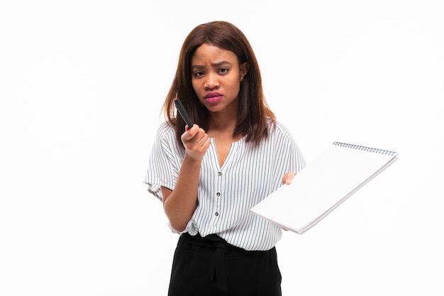 Charming dark-skinned young woman explain smth on the plane table isolated