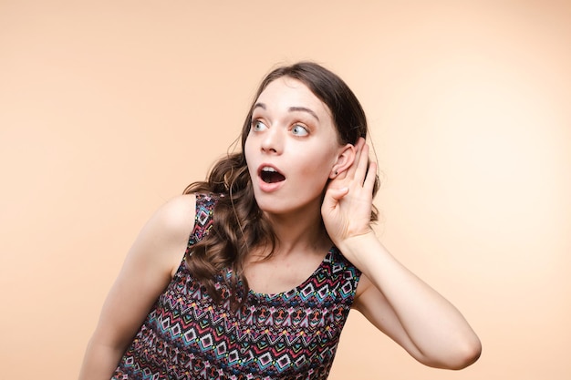 Charming girl listening to gossips Studio portrait of beautiful caucasian