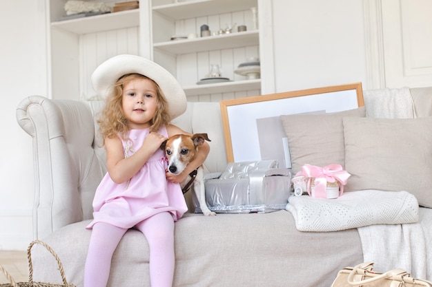 Charming girl posing with dog on sofa