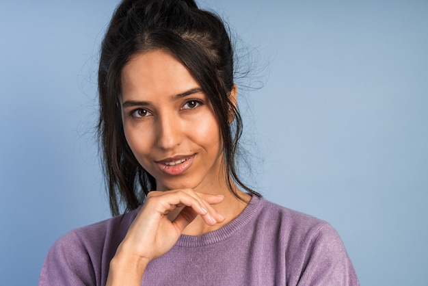 Charming girl   touches her face. Young woman posing  .