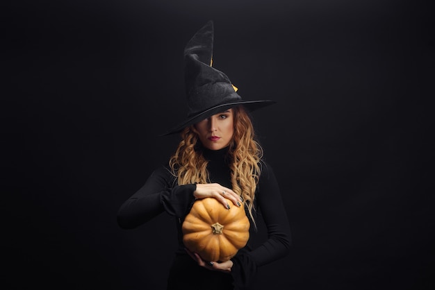 Charming halloween witch over black wall