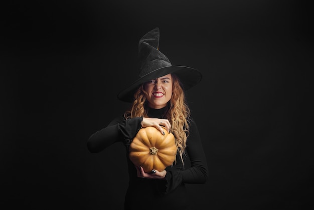 Charming halloween witch over black wall