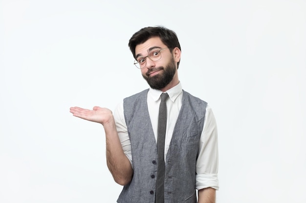 Charming handsome young hispanic man holding his hand up to show present sell product