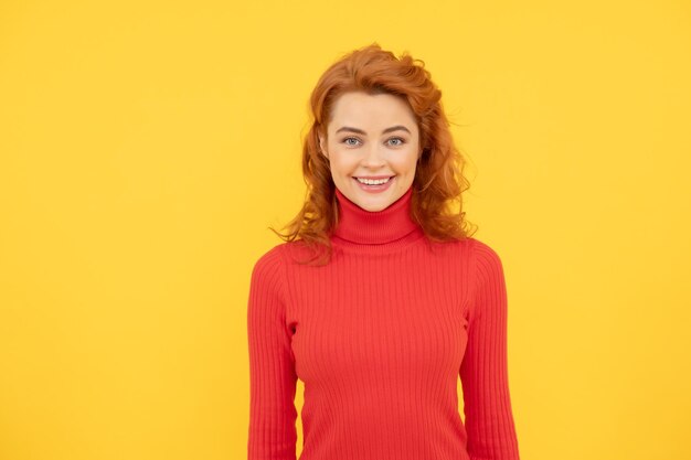 Charming happy redhead woman face portrait on yellow background happiness