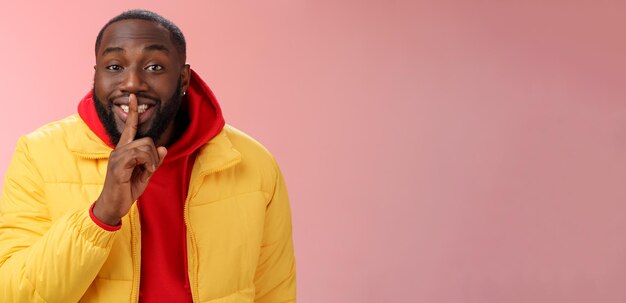 Charming happy young africanamerican bearded guy in yellow jacket red hoodie prepare lovely birthday