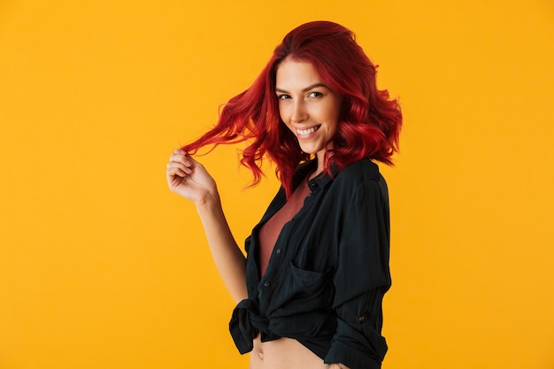 charming joyful woman with curly red hair smiling isolated