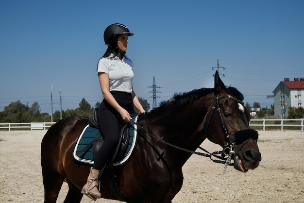 Charming lady in helmet sitting confidently in saddle