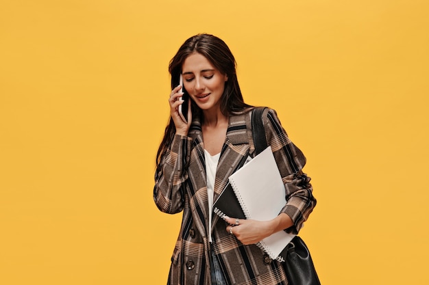 Charming lady in oversized jacket talks on phone