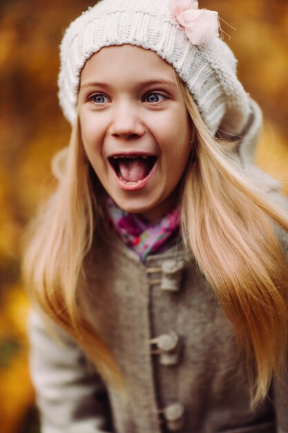 Photo charming little girl laughs - happy girl. charming autumn.