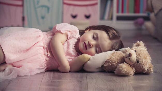 Charming little girl in pink dress looks lovely while she sleeps on the floor