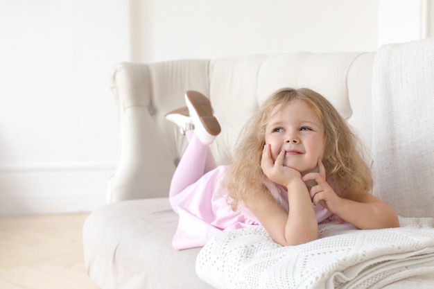 Charming little girl posing on sofa