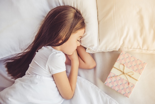 charming little girl sleeping in her bed at home