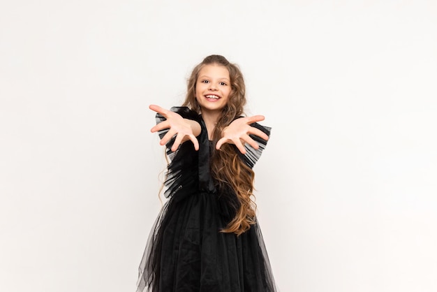 A charming little girl with curly hair and a fluffy dress on a white isolated background A beautiful princess on Black Friday