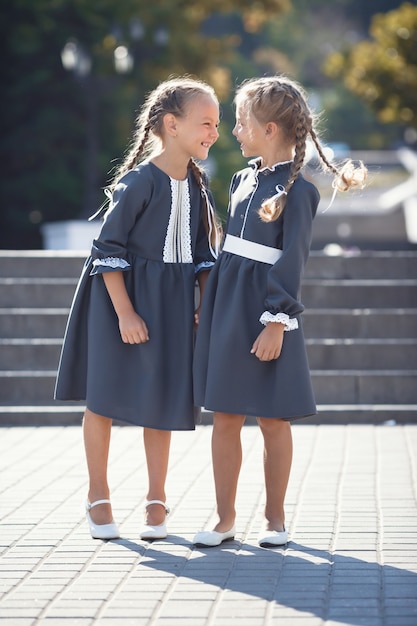 Очаровательные маленькие девочки в ретро-платье гуляют по городу в солнечный летний день