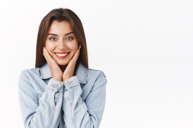 Foto affascinante, adorabile ragazza bruna caucasica che splende dalla felicità e dalla gioia, sorridente sciocca,