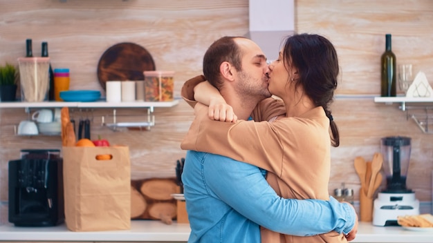 Affascinante coppia sposata piena di felicità che balla in cucina. la giovane famiglia felice allegra balla insieme. divertimento amore affetto romanticismo tempo libero musica romantica per divertimento music