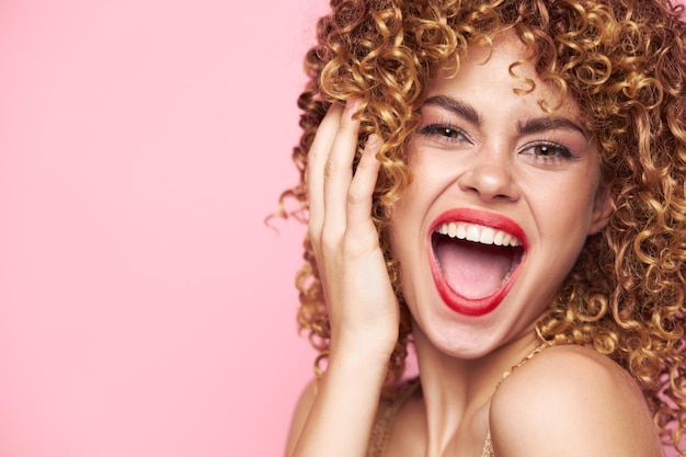 Charming model Energetic appearance wide open mouth emotions curly hair pink background