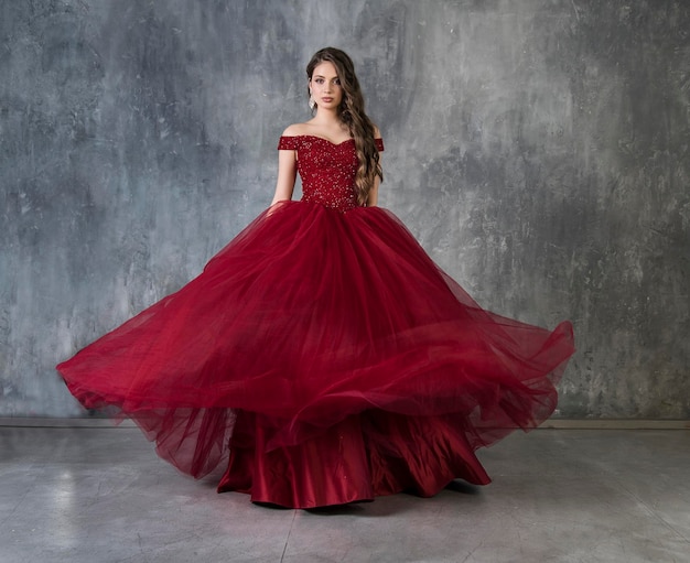 Charming model in an evening cocktail dress poses demonstrating her coquetry and charm