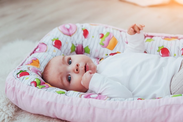 charming newborn baby in a pink cradle