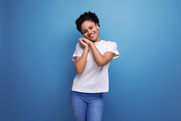 Charming owner of curly hair woman dressed in a white tshirt on an isolated background with copy