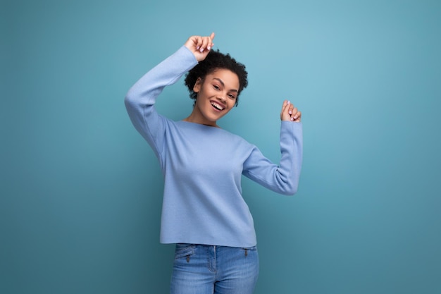 Affascinante donna bruna sorridente con riccioli afro che mostrano gioia