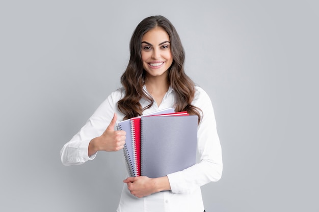회색 배경에 고립 된 매력적인 학생 여자 고등학생 잡고 노트북 교육