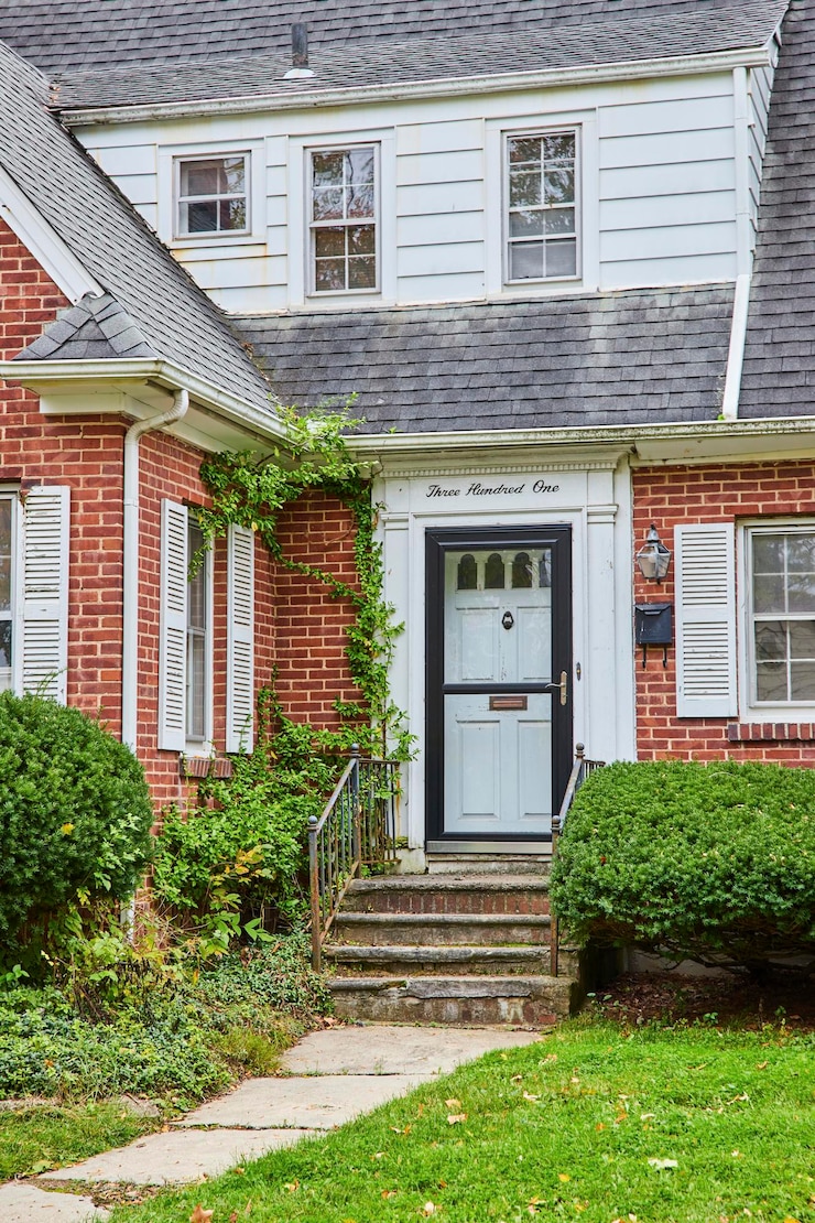 Photo charming suburban home with ivy and shingled roof overcast day