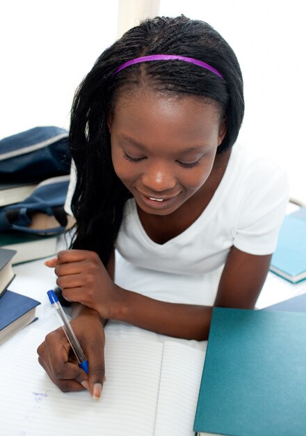 Charming teen girl studying lying on her bed