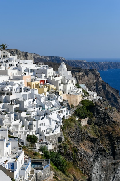 写真 ギリシャ サントリーニ島のフィラ村の魅力的な景色 エーゲ海のカルデラの上にある有名な青いドームの伝統的な教会 伝統的な青と白のキクラデスの建築