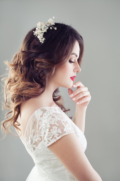 Charming woman fiancee looking down Bridal hair makeup and wedding dress