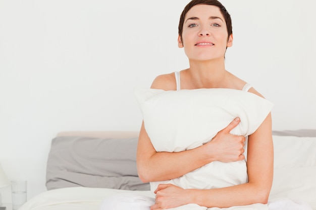 Photo charming woman holding a pillow