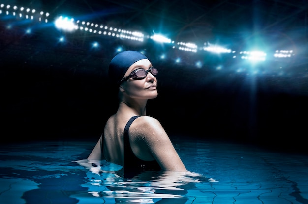 Charming woman posing in a pool against the backdrop of a stadium