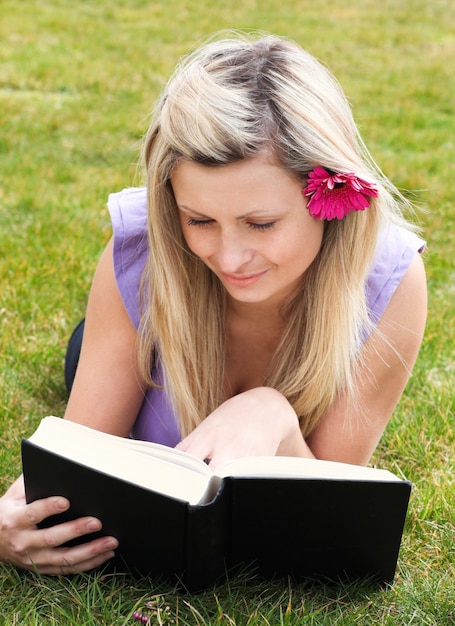 Foto donna affascinante che legge un libro in un parco