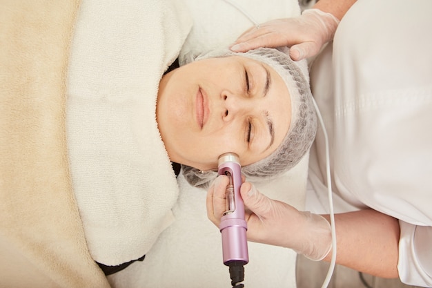 Charming woman receiving electroporation treatment at wellness center