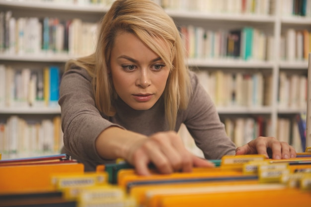 Foto donna affascinante che studia alla biblioteca