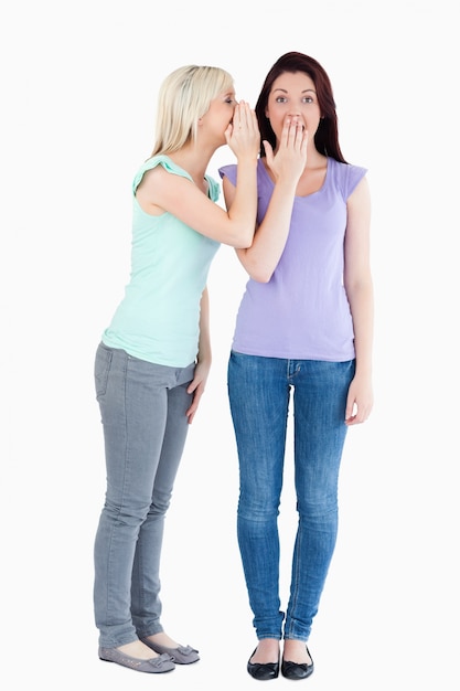 Charming woman telling her friend a secret