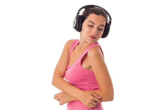 Charming woman with headphones isolated on white wall