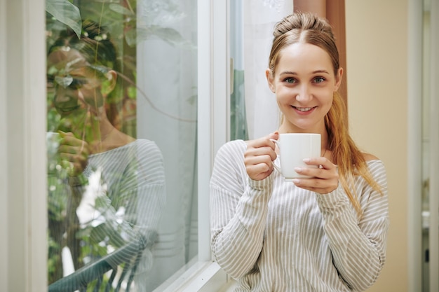 お茶のマグで魅力的な女性