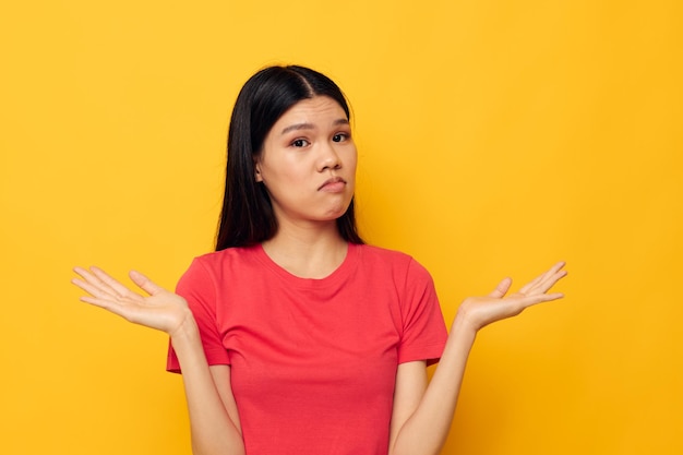 Charming young Asian woman in a red tshirt posing emotions fun isolated background unaltered