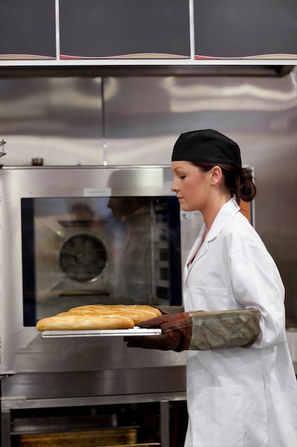 Charming young baker with baguettes