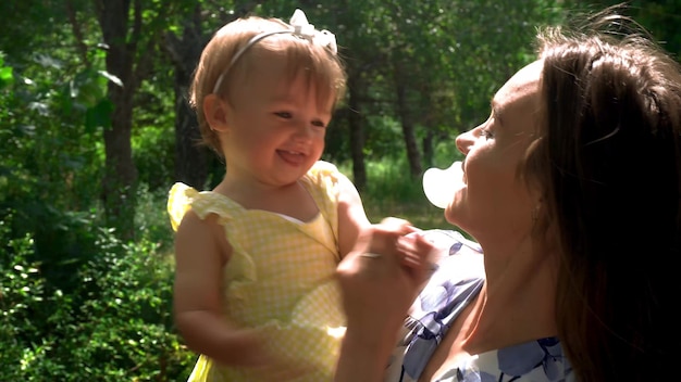 Charming young mother having fun with her little daughter at the garden