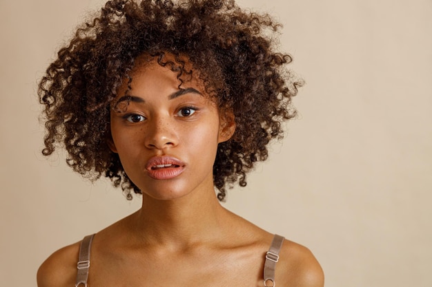 Charming young woman looking at camera in studio