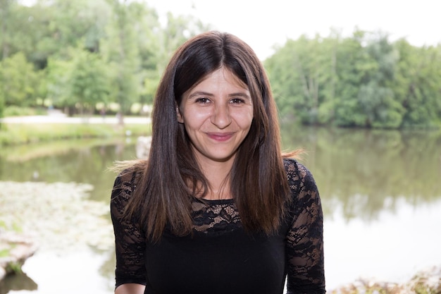 Foto affascinante giovane donna con i capelli lunghi su un fiume durante l'estate