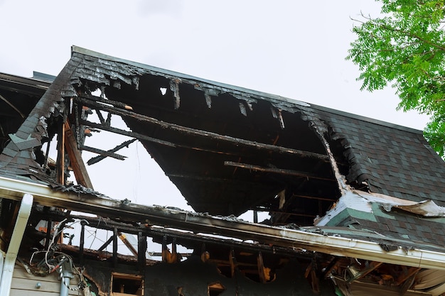 A charred black wall of a log house after a fire