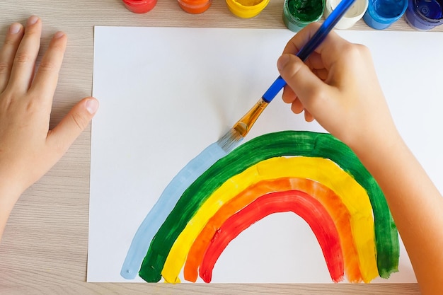 家で虹を追いかける 子供は窓に虹を描く 子供たちは芸術家の絵を描く 創造性 休暇