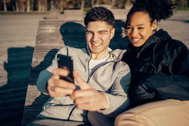 Photo chat with friends via video link selfies are taken on the phone young couple walking in the park