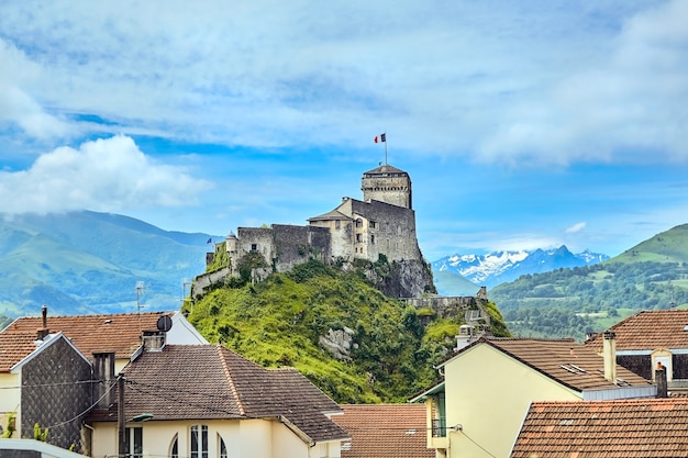 Chateau Fort of Lourdes Castle on a rock, landmark snowy mountain peaks