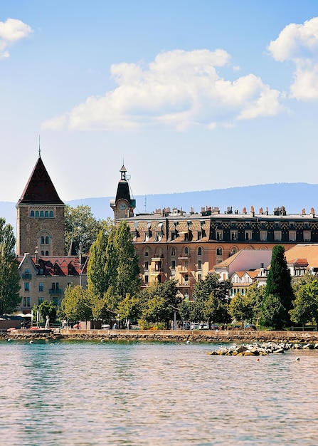 Chateau Ouchy op de promenade van het Meer van Genève in Lausanne, Zwitserland. Mensen op de achtergrond