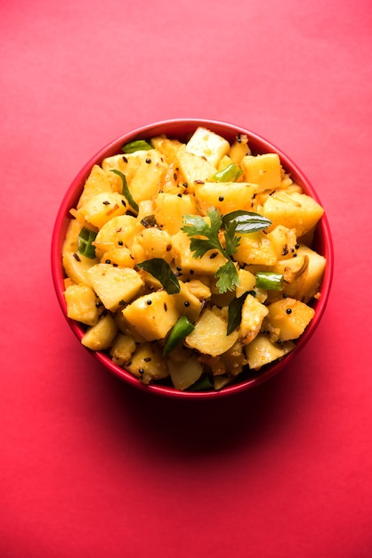 Chatpate Masala Aloo Sabzi fry OR Bombay potatoes served in a bowl, selective focus