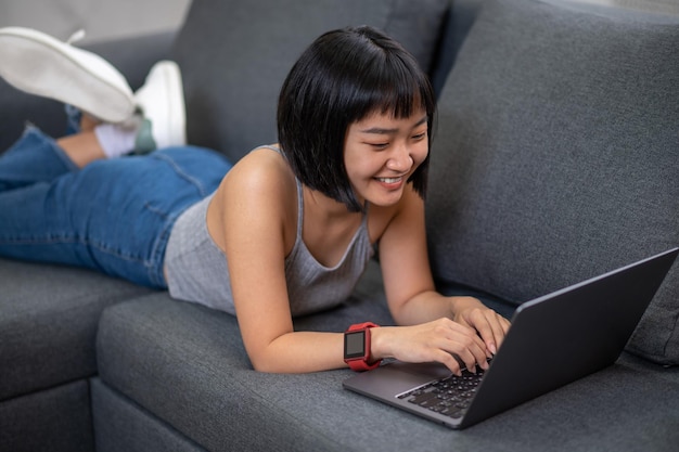 Chatting. A cute young asian girl chatting online and looking excited